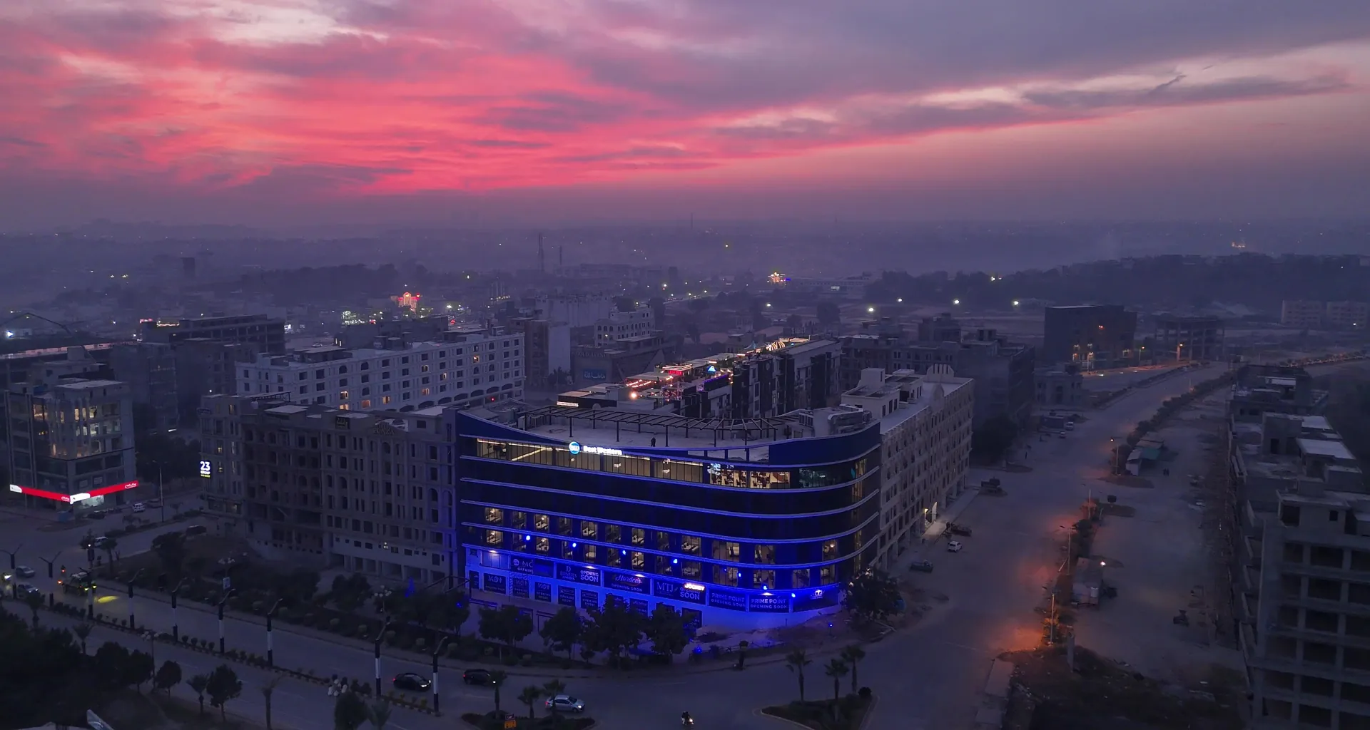 Aerial view of Melrose Arch lit in blue at dusk