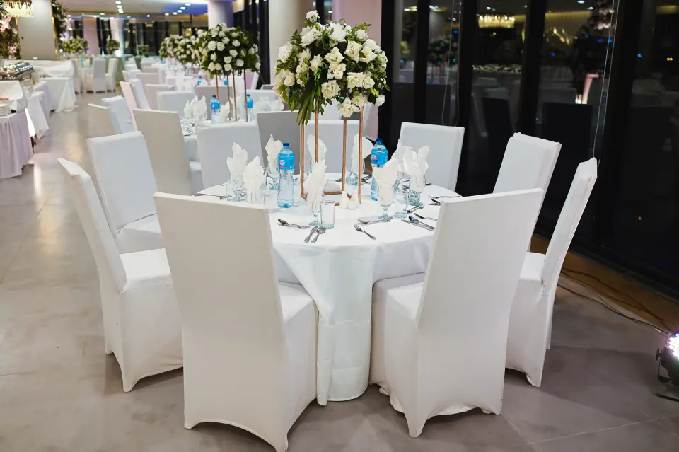 White banquet tables and chairs set for dinner at Melrose Arch