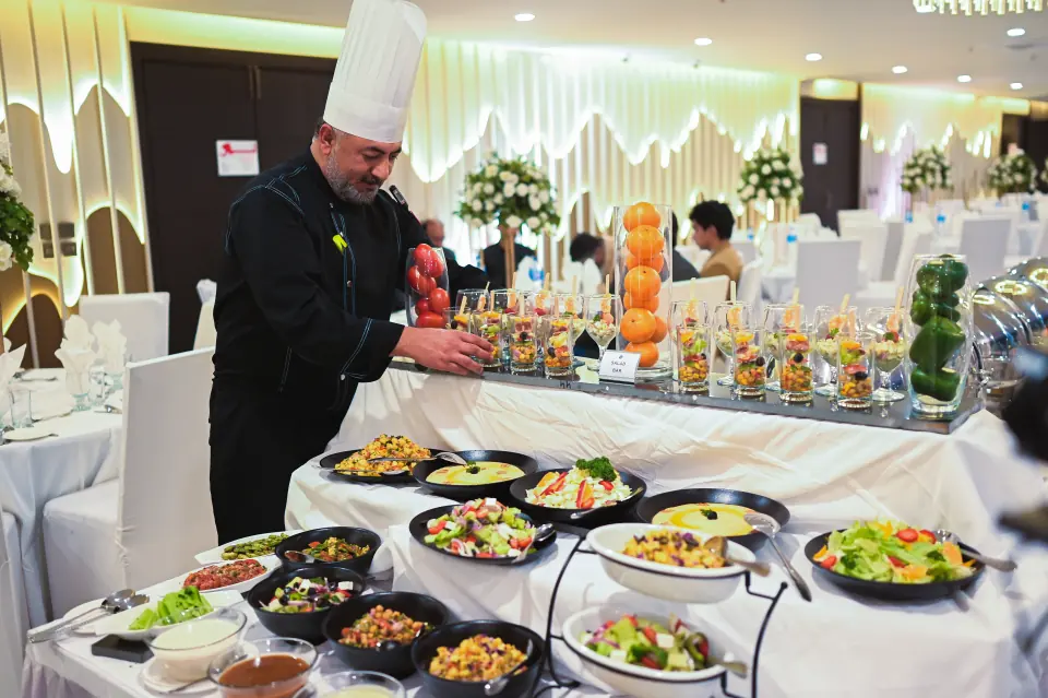 Chef preparing a live food station at a Melrose Arch event